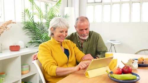 Senior Couple Using Tablet Device Together at Home