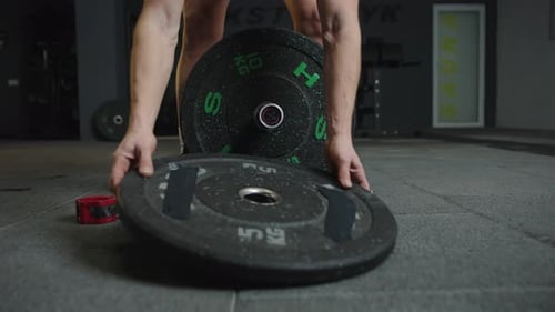 Slow motion weightlifting in gym showing technique and strength training with heavy plates