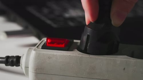 Woman Plugged in Power Cable for Computer and Turns on Work Indicator Button Closeup