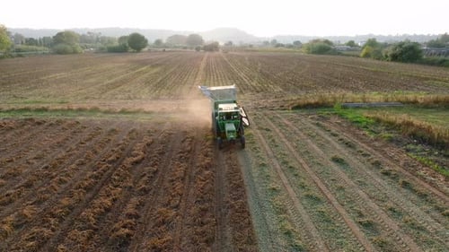 Tractor Harvesting Crops in Rural Farm Field