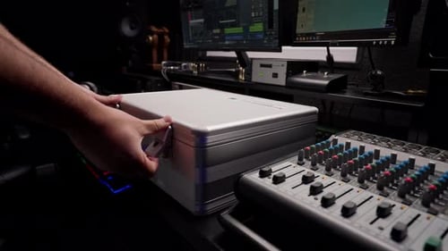 close-up shot of the male hand of a sound engineer switching settings on mixing console recording