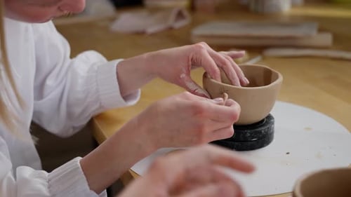 Potter Adding Clay Details to Small Clay Bowl