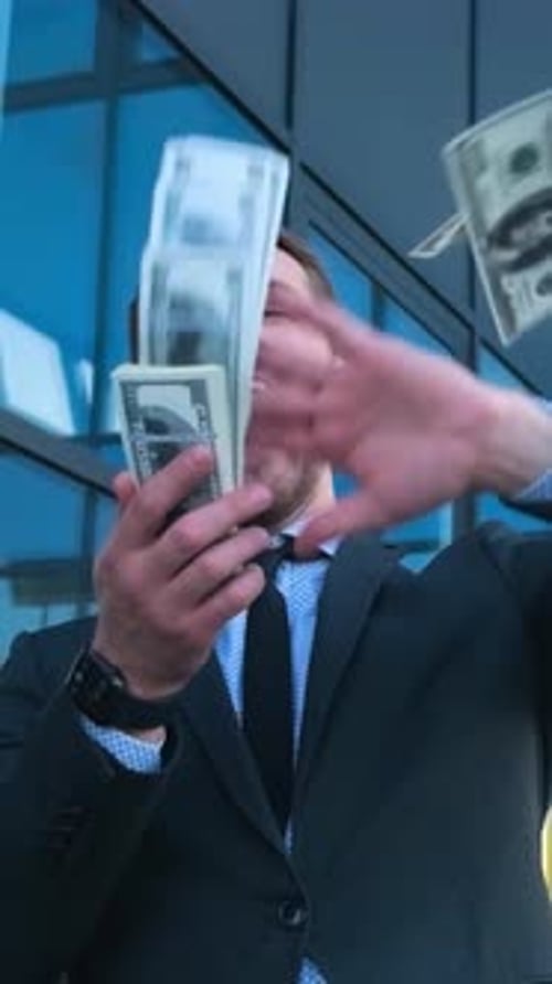 A Man in Formal Wear Holding a Stack of Money in Front of His Face