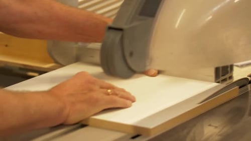 Man using a table saw to cut wood