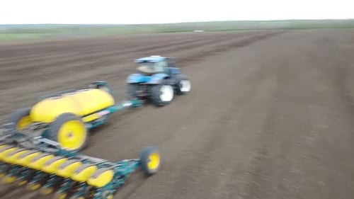 Blue tractor OA working on the field in Ukraine
