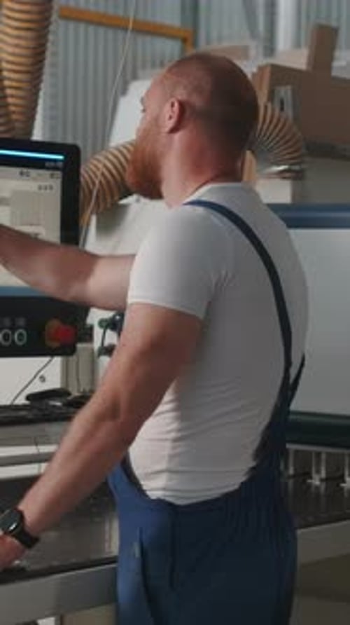 Man Clicks on Control Panel Creative Man with Beard in Work Uniform at Factory Man Adjusts Control