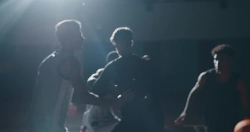 Cinematic slow motion close up shot of young professional male players are practicing a basketball