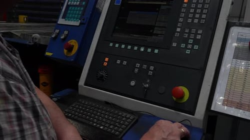Man Operating Computerized Industrial Equipment in Factory Workplace