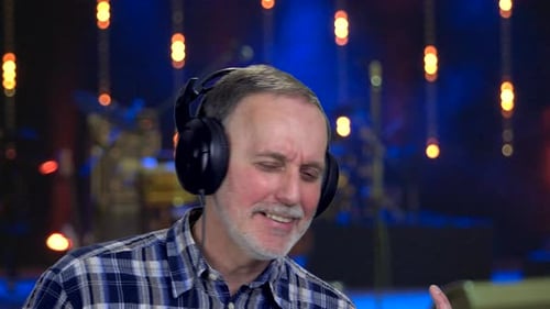 Person with Headphones Speaking to Someone Offscreen