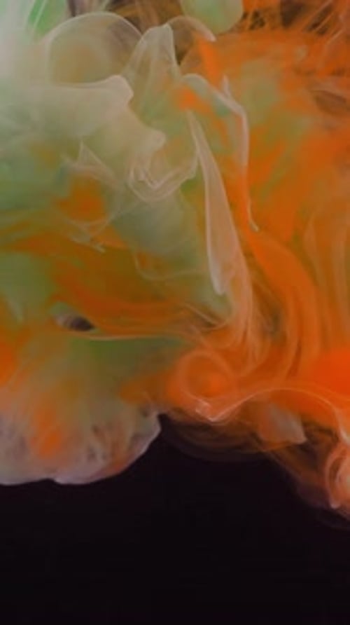 Abstract Footage of Green and Orange Ink Swirling