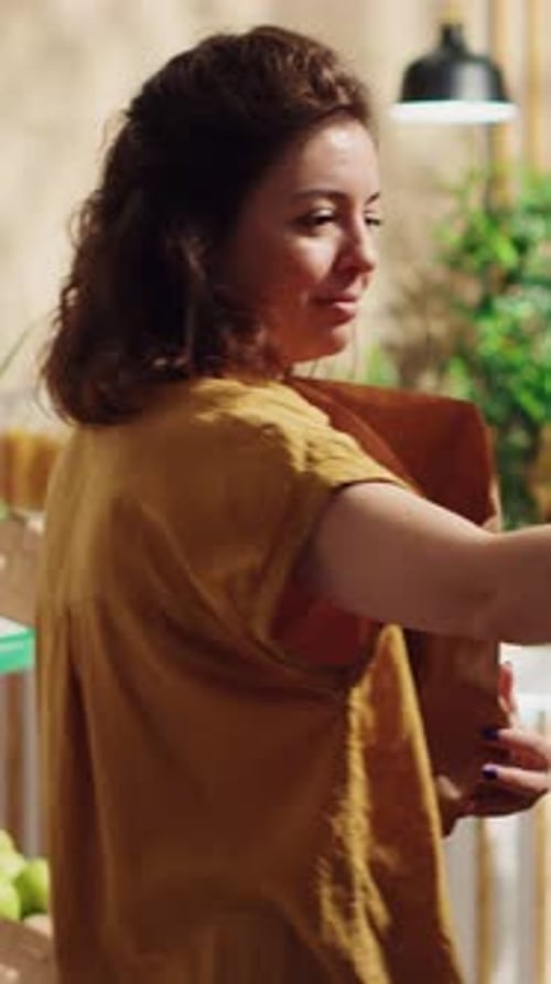 Vídeo vertical de mujer usando bolsa de papel en Bio Store