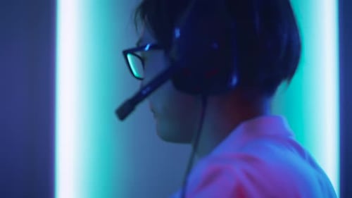 Close-up Portrait Shot of the Professional East Asian Gamer Playing in Online Video Game on His Pe