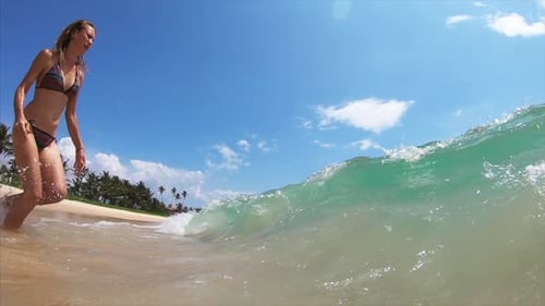 Young happy woman run into the sea with lot of splashes