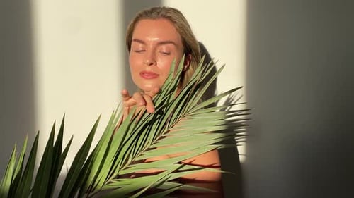 Woman Posing with Tropical Leaf in Bright Light