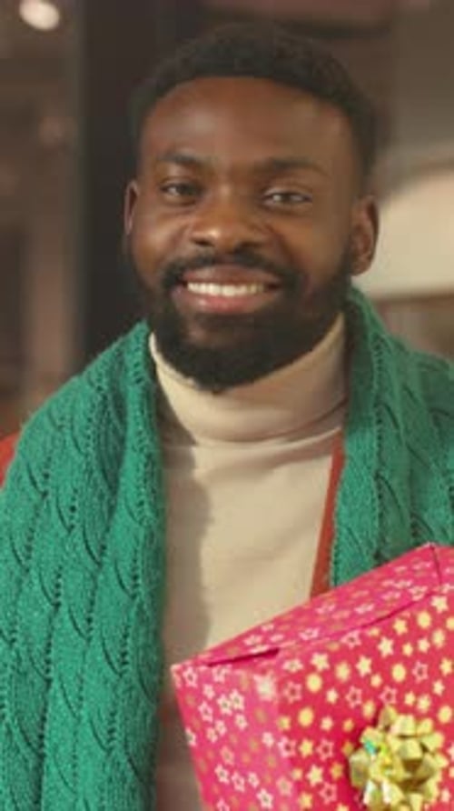 Smiling Man with Gift Inside Shop Happy Customer and Supporter Celebrating Festive Season Together