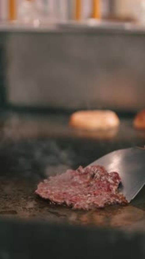 Hamburger Patty Cooking on Grill at Restaurant Kitchen