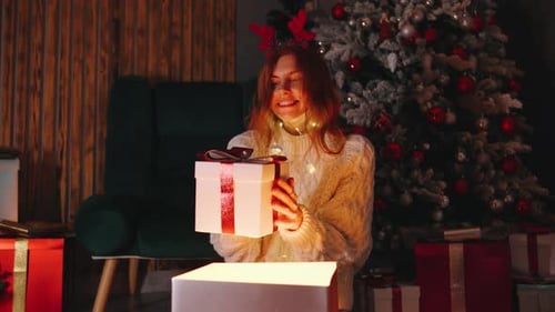 Woman Opens Gift at Christmas Indoors
