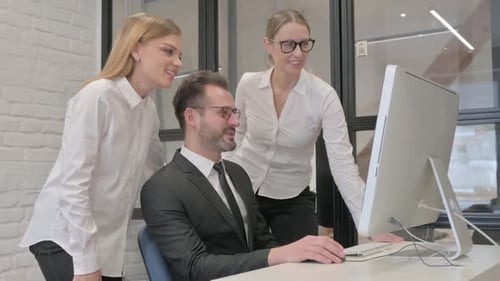 Happy Colleagues Collaborate at Computer in Modern Office