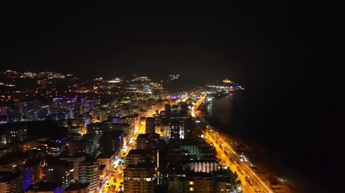 Aerial View Nighttime Cityscape with Colorful Building Lights and Street Lamps