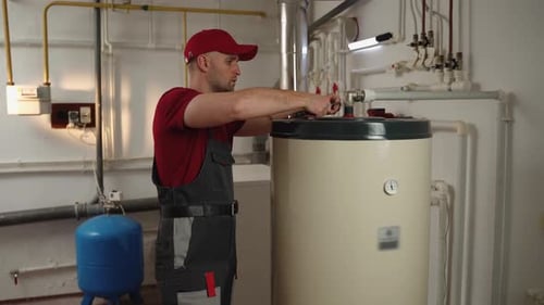 Skilled Technician Conducts Boiler Maintenance in a Residential Utility Room