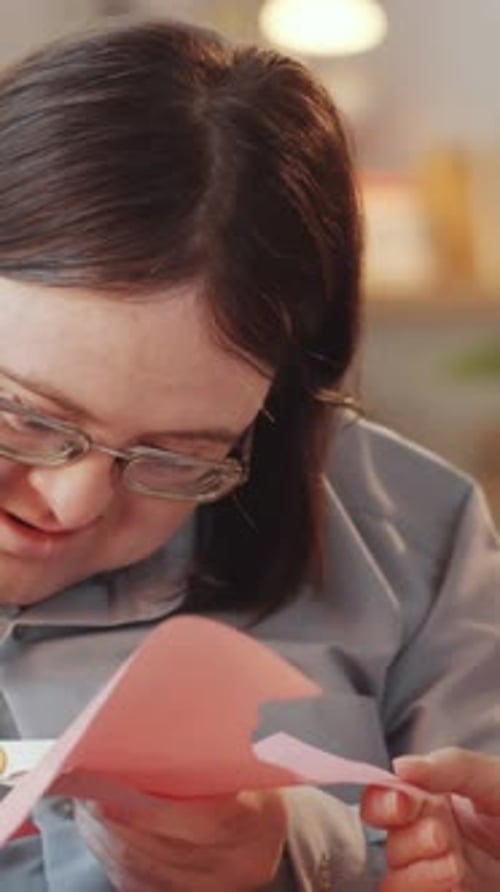 Person Cutting Paper With Scissors in Home