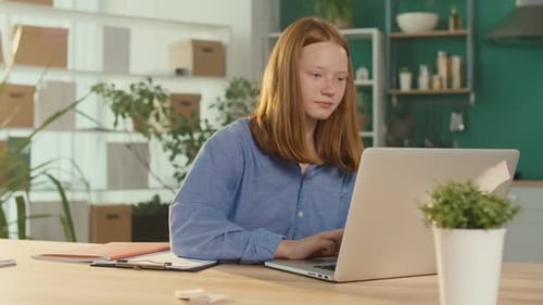 Girl Uses Laptop at Desk in Bright Room