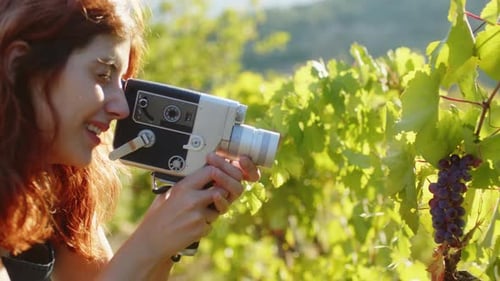Girl with Vintage Super 8Mm Shoot Film Near the Grapes in Vineyard