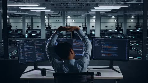 Back View Of Tired Asian Man Developer Stretching While Write Code In Data Center