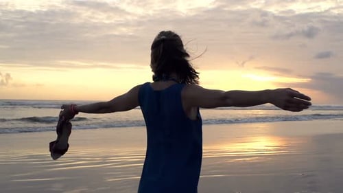Frau genießt Sonnenuntergang am Strand in der Nähe des Meeres, Superzeitlupe 120fps