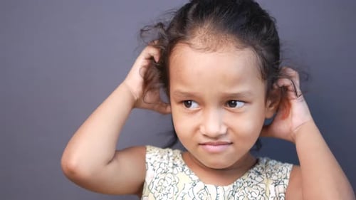 Little Girl Scratching Head in Close Up