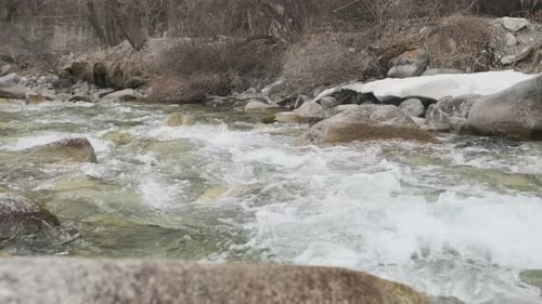 Rio de montanha que flui entre costões rochosos Verão Rio de montanha em madeira, água e pedras lentas