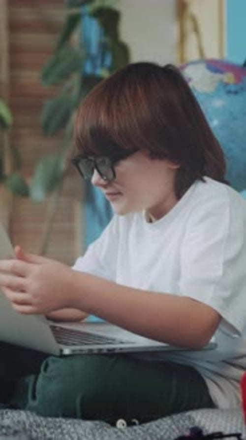 Junge entspannt sich mit Gaming-Ausrüstung Entspannter junger Programmierer spielt und lernt zu Hause