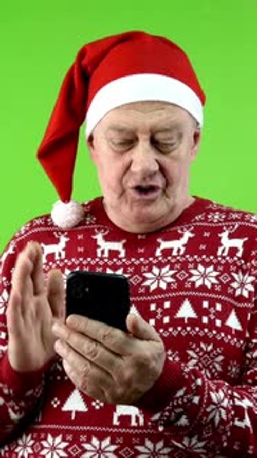 Senior Man Video Calling with Santa Hat on GreenScreen