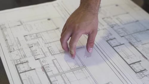 Architect Reviewing Blueprint of Building Floorplan