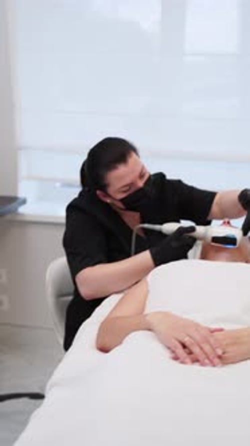 Professional Aesthetician Performs Endospheres Therapy Massage on Clients Face in Clinic Noninvasive