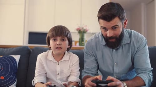 Father and Son Playing Video Games on Couch