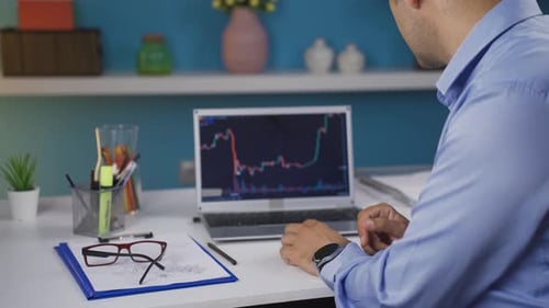 Investor looking at the stock market chart. He claps when he wins.