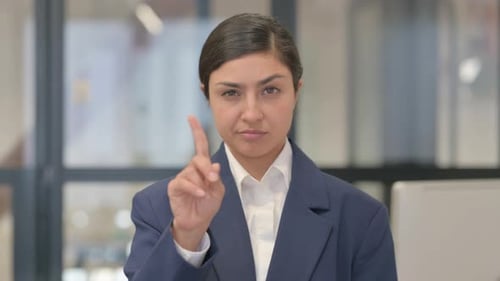 Woman Motioning No With Finger in Office Setting