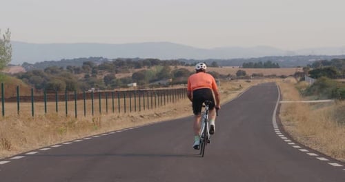 Professional Cyclist Man Training on a Road in Nature