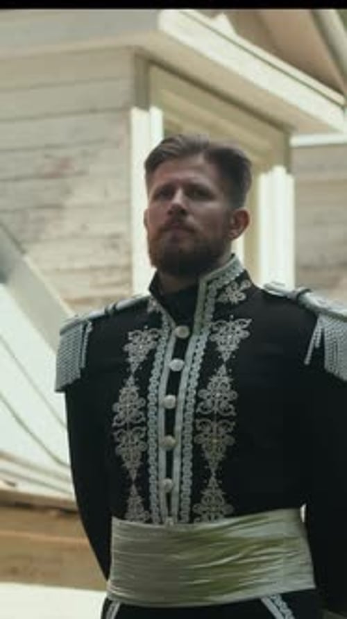 Man in Ornate Uniform Walking Outside Historical Building