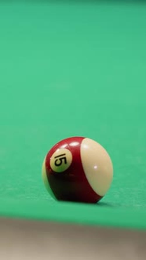 White Billiard Ball Rolling on Green Pool Table After Striking Another Ball