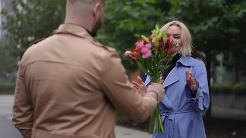 Romantic Man Gives Flowers to Woman on City Street