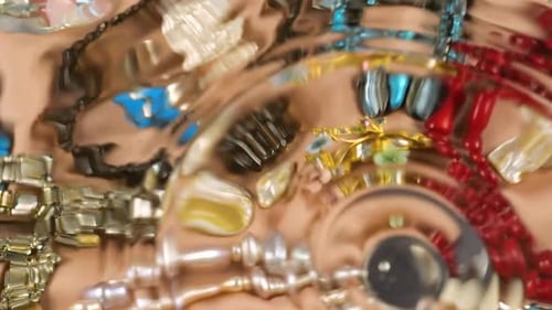 Bijoux en pierres précieuses et perles sur fond de soie beige sous l'eau.