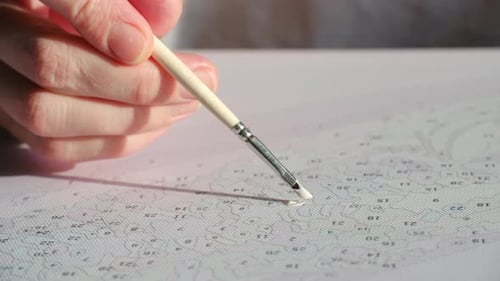 Hand Painting Numbers with Fine Brush and White Paint