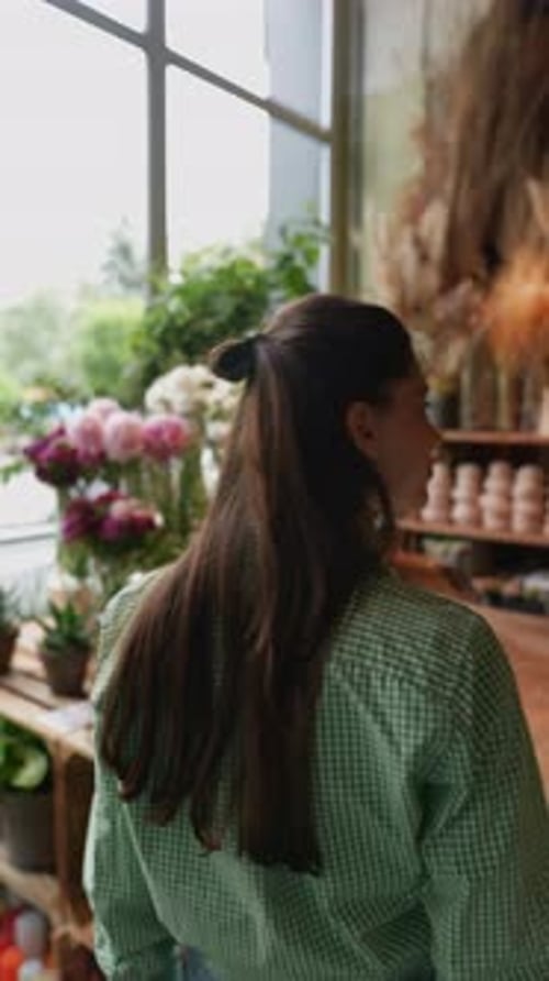 The Customer a Young Woman is Scrutinizing the Items Available at the Flower Store