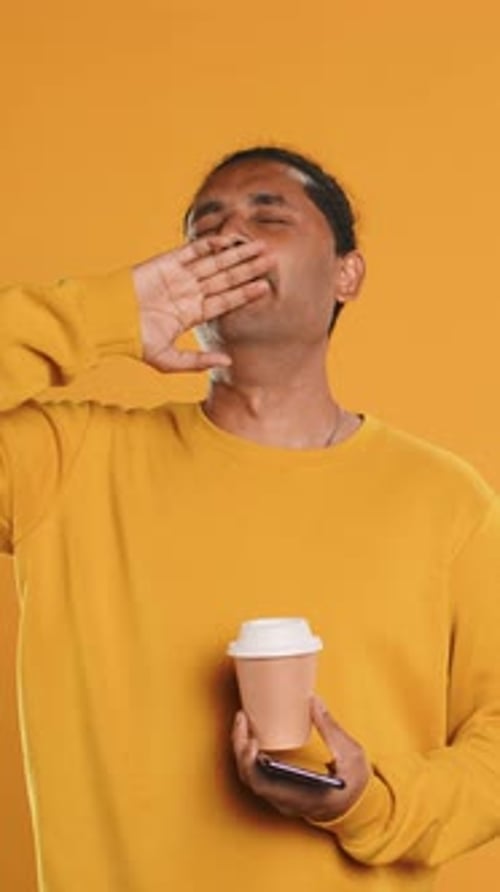 Man Drinking Coffee and Chatting with Friends on Mobile Phone Studio Background