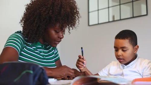 Woman Helping Boy with Schoolwork at Home
