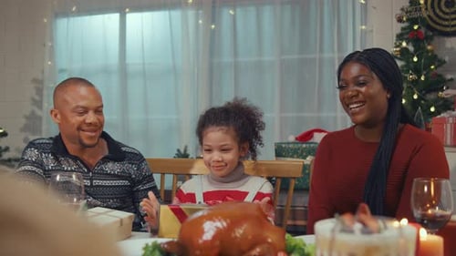 Family Celebrates Christmas Together with Food and Gifts