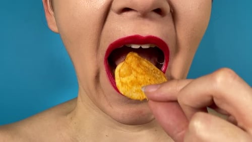 Close-up female mouth with colored lips eats food isolated background