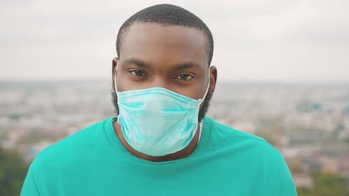 Person Wearing Mask in Front of City